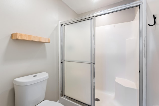 bathroom featuring an enclosed shower and toilet