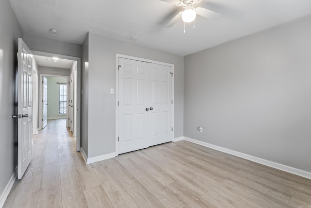 unfurnished bedroom featuring a closet, ceiling fan, and light wood-type flooring