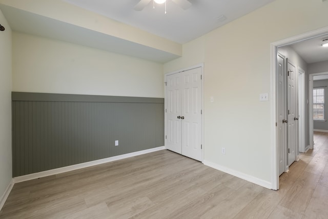 unfurnished bedroom featuring ceiling fan, light hardwood / wood-style floors, and a closet