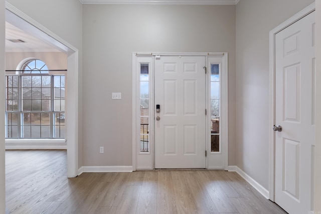 entrance foyer featuring crown molding and light hardwood / wood-style flooring