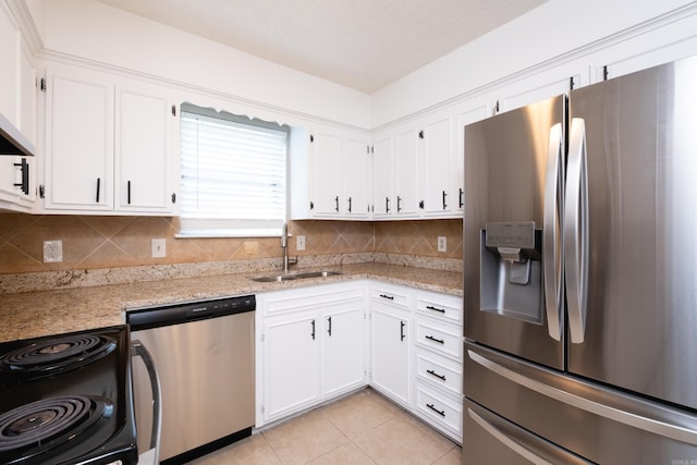 kitchen featuring stainless steel appliances, light tile patterned flooring, sink, and white cabinets