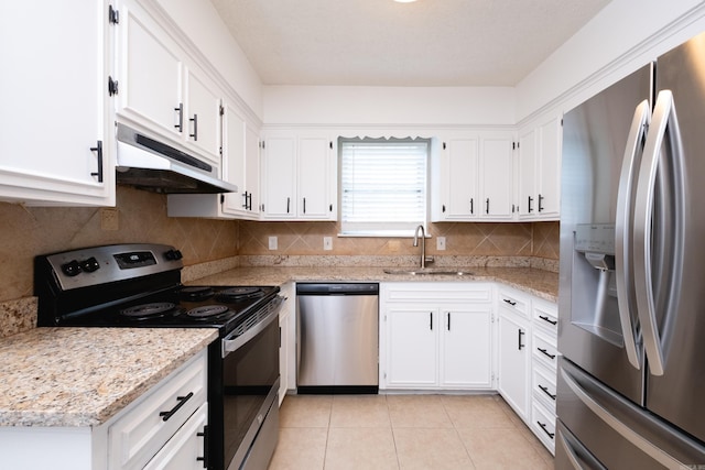 kitchen featuring appliances with stainless steel finishes, sink, white cabinets, light tile patterned floors, and light stone countertops