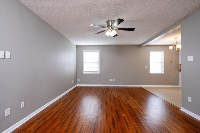 spare room with ceiling fan with notable chandelier, hardwood / wood-style floors, and a textured ceiling