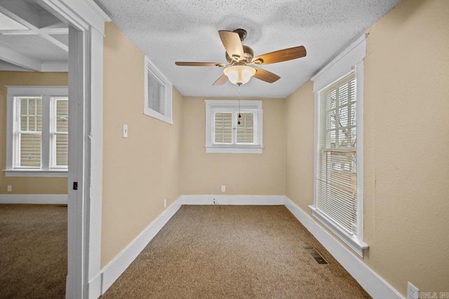 carpeted spare room featuring ceiling fan and a textured ceiling