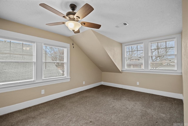 bonus room featuring ceiling fan, vaulted ceiling, a textured ceiling, and carpet