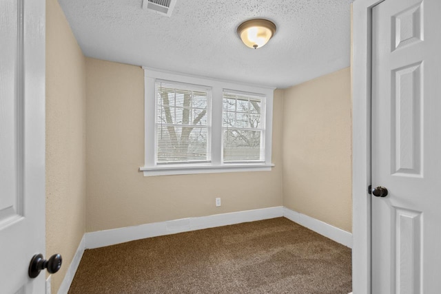 carpeted spare room featuring a textured ceiling