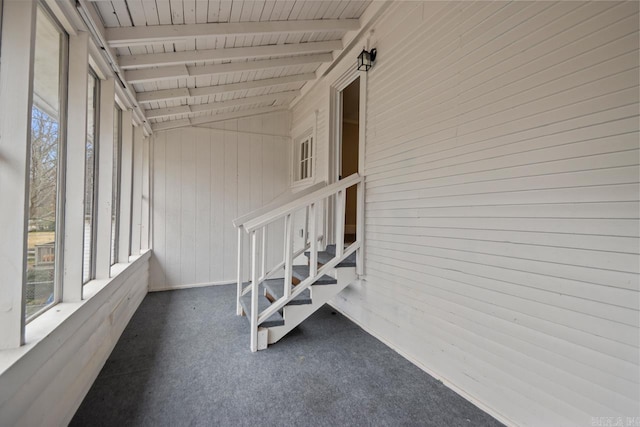 unfurnished sunroom with wooden ceiling, a healthy amount of sunlight, and vaulted ceiling with beams