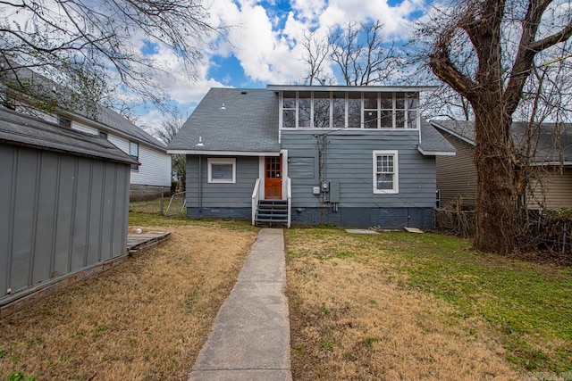 rear view of property featuring a sunroom and a lawn