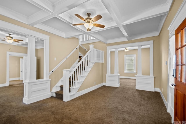 unfurnished living room featuring dark colored carpet, a healthy amount of sunlight, coffered ceiling, and ornate columns