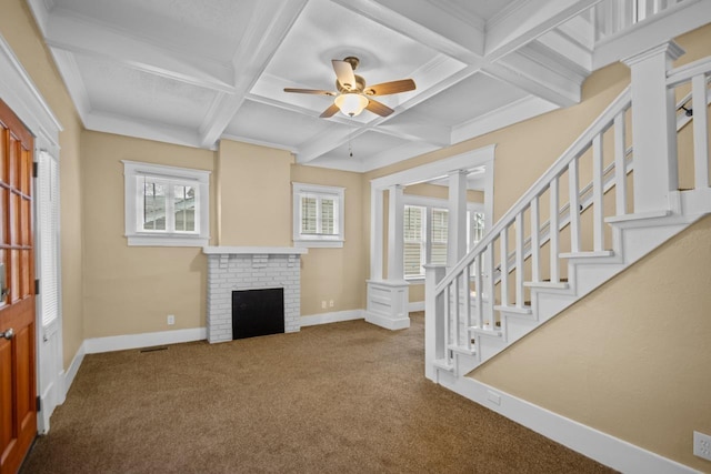 unfurnished living room featuring coffered ceiling, beamed ceiling, ceiling fan, a fireplace, and carpet