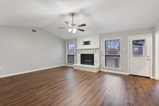 unfurnished living room with lofted ceiling, a fireplace, dark hardwood / wood-style flooring, and plenty of natural light