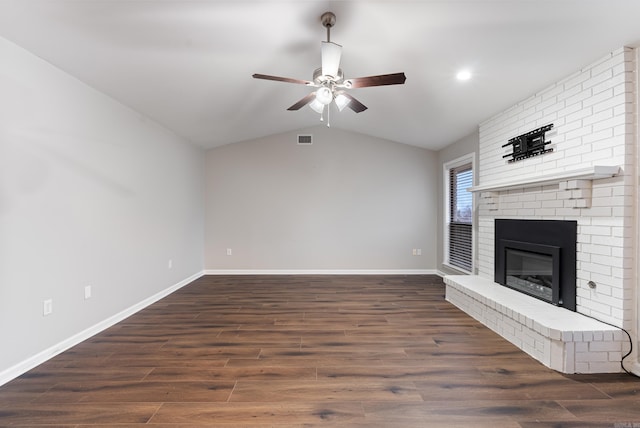 unfurnished living room featuring dark hardwood / wood-style flooring, a brick fireplace, vaulted ceiling, and ceiling fan