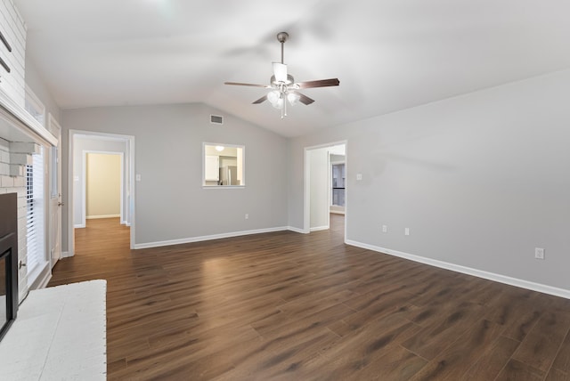 unfurnished living room featuring lofted ceiling, dark hardwood / wood-style flooring, a fireplace, and ceiling fan