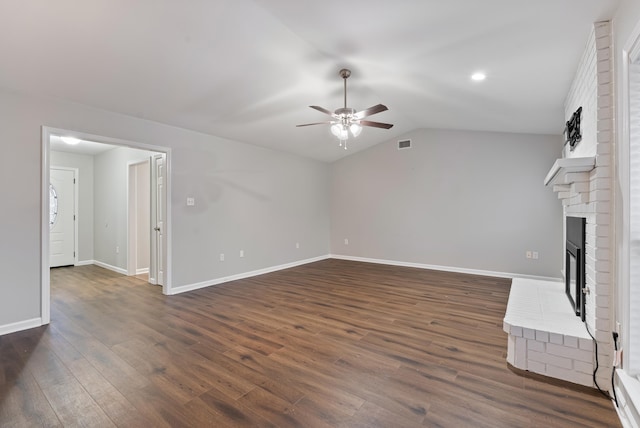 unfurnished living room with dark hardwood / wood-style floors, ceiling fan, a fireplace, and vaulted ceiling