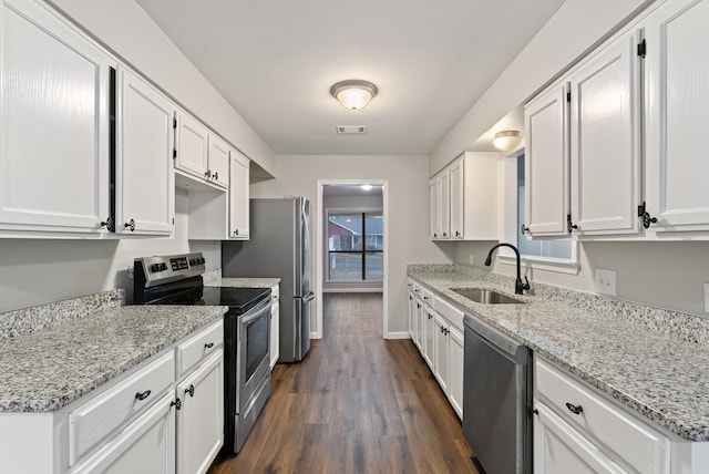 kitchen with dark wood-type flooring, stainless steel appliances, sink, and white cabinets