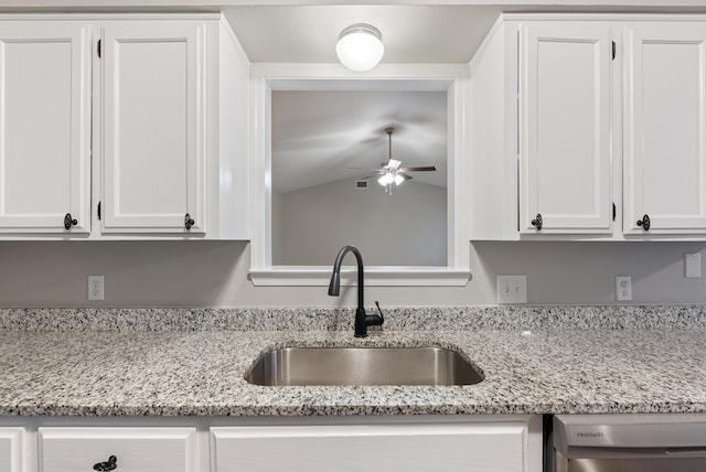 kitchen with light stone counters, dishwasher, sink, and white cabinets