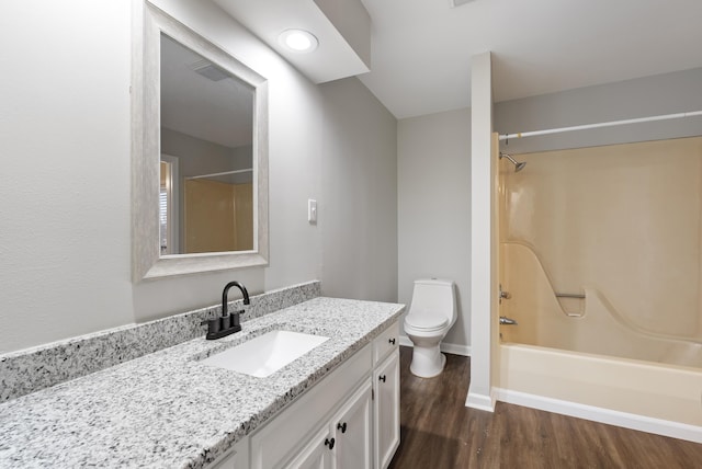 full bathroom featuring hardwood / wood-style flooring, vanity, shower / bath combination, and toilet