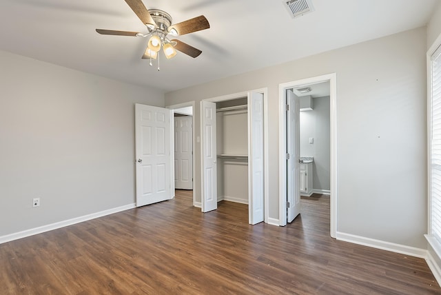 unfurnished bedroom with dark hardwood / wood-style flooring, a closet, and ceiling fan