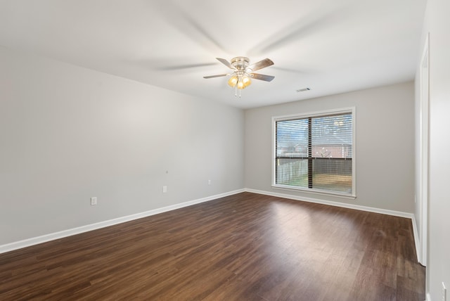 spare room featuring dark wood-type flooring and ceiling fan