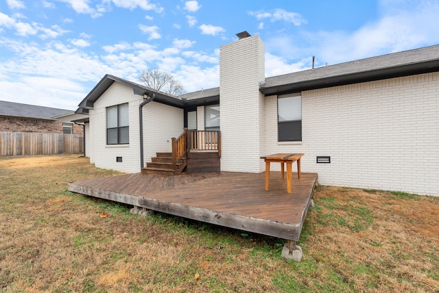 back of property with a wooden deck and a lawn