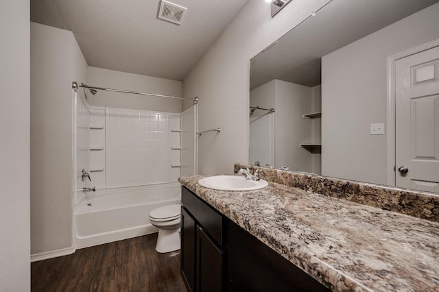 full bathroom with vanity, hardwood / wood-style floors, shower / washtub combination, and toilet