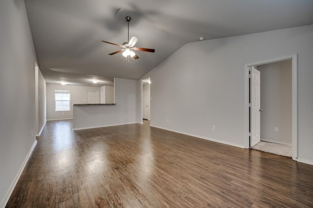 unfurnished living room with dark wood-type flooring, ceiling fan, and vaulted ceiling