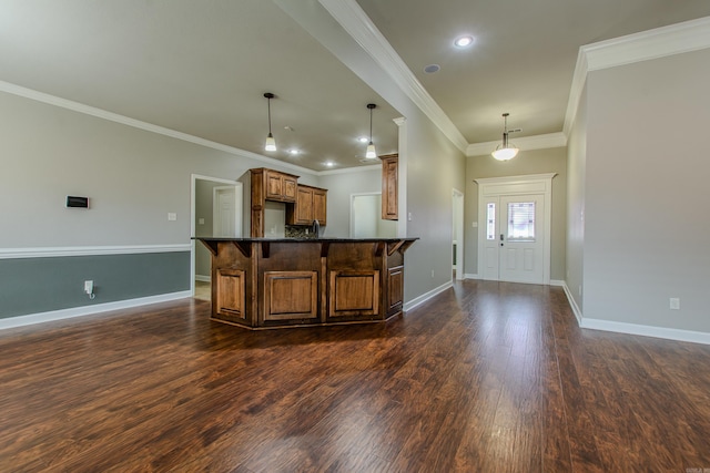 kitchen featuring pendant lighting, crown molding, dark wood-type flooring, and a kitchen breakfast bar