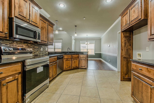 kitchen featuring tasteful backsplash, hanging light fixtures, light tile patterned floors, ornamental molding, and stainless steel appliances