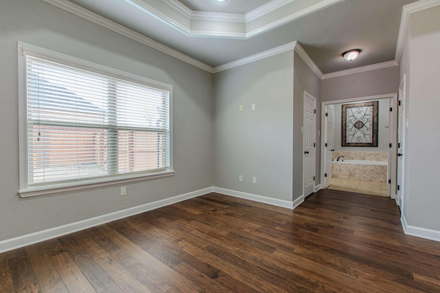 empty room with dark hardwood / wood-style flooring, ornamental molding, and a raised ceiling