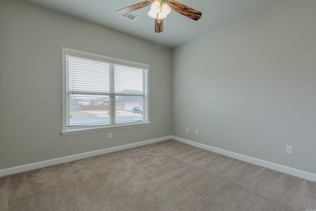 spare room with ceiling fan and light colored carpet