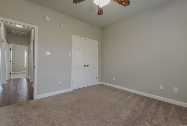 unfurnished bedroom with dark colored carpet, ceiling fan, and a closet