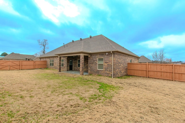 rear view of house featuring a yard and a patio area