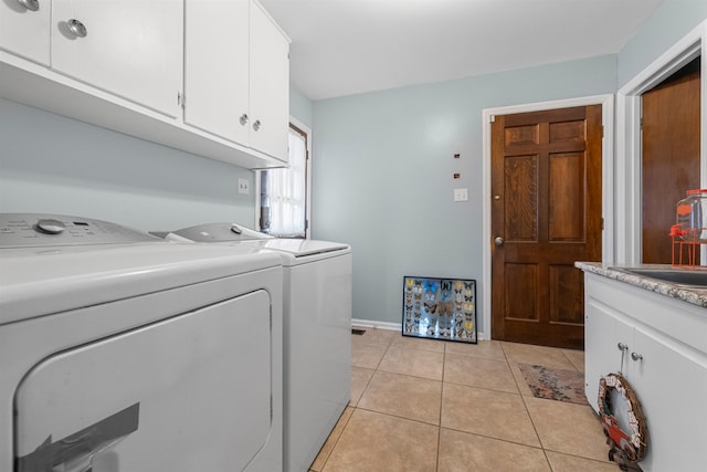 laundry area with sink, cabinets, light tile patterned floors, and washer and dryer