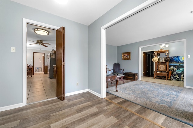 entryway with wood-type flooring and ceiling fan with notable chandelier