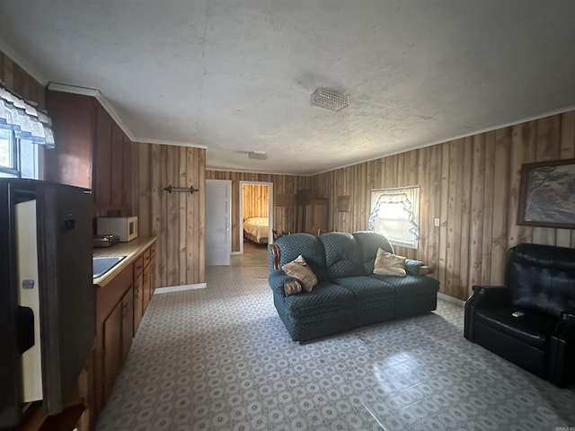 living room featuring crown molding, wooden walls, and sink