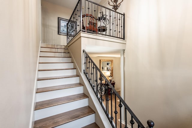 stairs with a towering ceiling and ornate columns