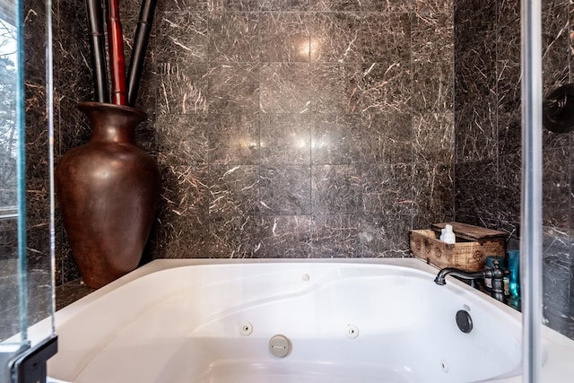 bathroom featuring a tub to relax in and tile walls