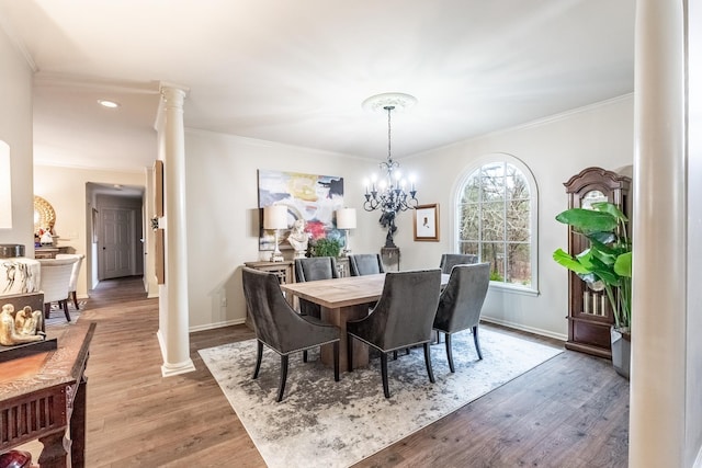 dining area featuring hardwood / wood-style flooring, an inviting chandelier, and decorative columns