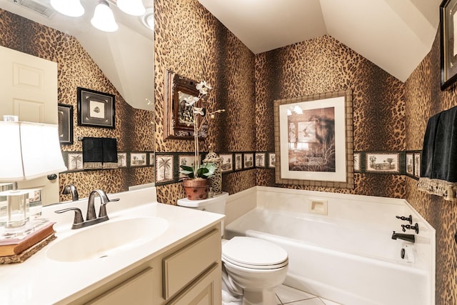 bathroom featuring a tub, lofted ceiling, vanity, toilet, and tile patterned floors