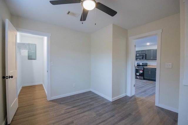 unfurnished room featuring dark wood-type flooring and ceiling fan