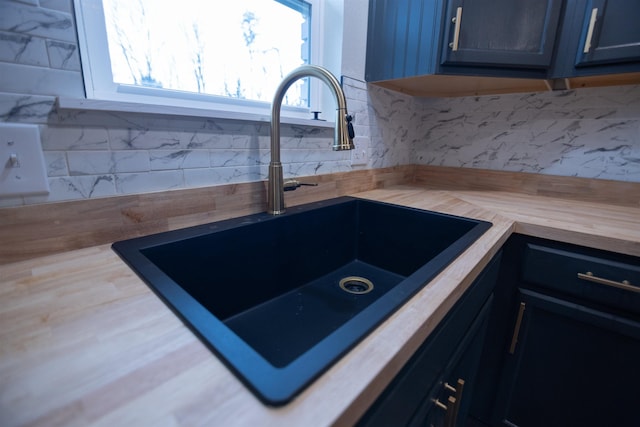 kitchen with tasteful backsplash, sink, and butcher block countertops