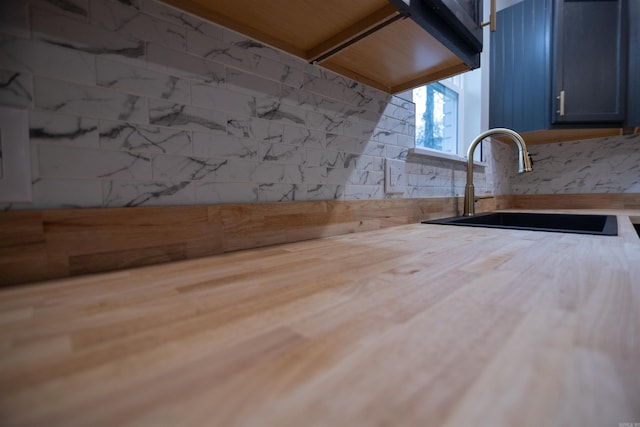 kitchen featuring blue cabinets, wood-type flooring, and sink