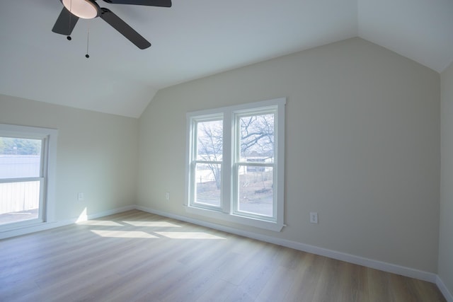 additional living space with vaulted ceiling, a healthy amount of sunlight, and light hardwood / wood-style floors