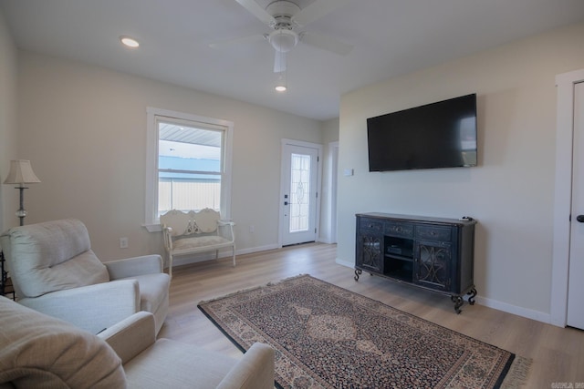 living room with ceiling fan and light hardwood / wood-style floors