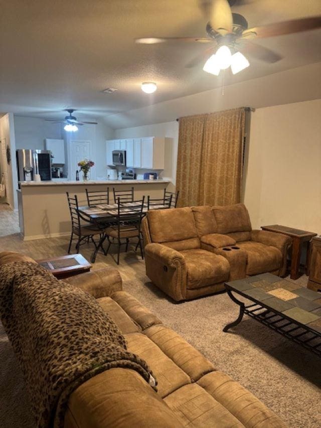 carpeted living room featuring ceiling fan