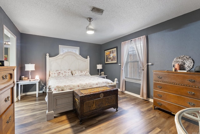 bedroom featuring multiple windows, dark wood-type flooring, and ceiling fan