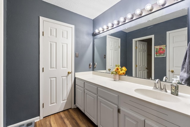 bathroom with vanity, hardwood / wood-style flooring, and a textured ceiling