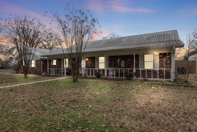 ranch-style house with a lawn and a porch