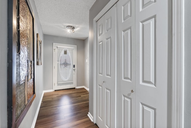 entryway with dark hardwood / wood-style flooring and a textured ceiling