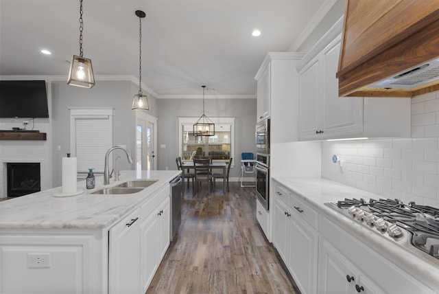 kitchen featuring white cabinetry, appliances with stainless steel finishes, a center island with sink, and premium range hood